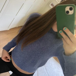 Blå stickad tröja från C.M. - Säljer en blå stickad tröja från C.M. i storlek XS. Tröjan är croppad och har lång ärm, perfekt för lager-på-lager. Mjuk och skön känsla, passar till många olika outfits.