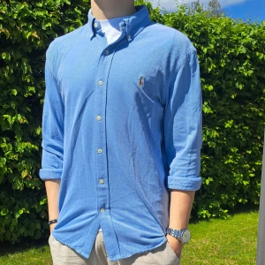 Ljusblå Ralph Lauren skjorta - Stl M Slim fit - Hej säljer en snygg Ralph Lauren skjorta I färgen ljusblå. Perfekt till sommaren! 🏖🏝 Skick: 8,5/10 bara en litet hål på vänster ärmen. Knappt något som syns vid användning. Modell: Slim fit. Storleken är ursprungligen en M. Bara att nån har klippt bort den biten där storleken stod. Hör av dig om du har några frågor. Mvh Galgen 🤗