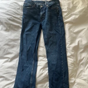 Weekday Jeans W30 L32 - Säljer ett par klassiska blå jeansbyxor från Weekday med rak passform och normal midja. Jeansen har fem fickor och stängs med dragkedja och knapp. Perfekta till vardags och enkla att matcha med olika stilar.