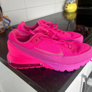 Nike Air Max sneakers i starkrosa - Säljer ett par riktigt snygga Nike Air Max sneakers i en intensiv rosa färg. Skorna har mesh-överdel för bra ventilation och en synlig Air Max-sula för extra komfort. Perfekta för dig som vill sticka ut med färg på fötterna! Använda endast 2 ggr.