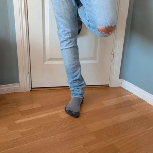 Ljusblå slitna jeans - Säljer ett par ljusblå jeans med skinny fit och normal passform. Jeansen har en tydlig slitning vid knät och klassiska bakfickor. Perfekta för dig som gillar en avslappnad men trendig stil.