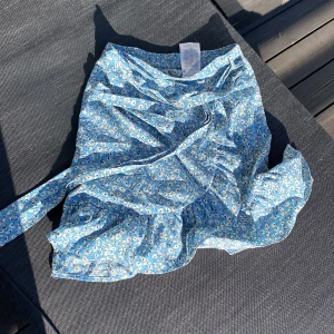 Ljuvlig Blommig blå omlottkjol från ONLY  - Söt blå omlottkjol från NLY med blommigt mönster. Kjolen har volangdetaljer och ett knytband i midjan. Perfekt för en somrig look!