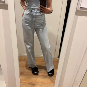 Ljusblå jeans med hög midja - Snygga ljusblå jeans med hög midja och en avslappnad passform. De har en klassisk femficksdesign och raka ben som ger en tidlös look. Perfekta för en casual stil, trådar på byxan har dock blivit sllitna och nästan gått av! 