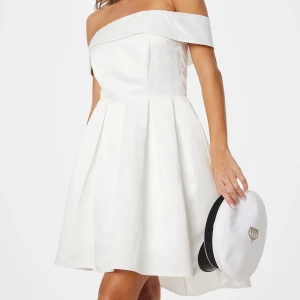 Vit offshoulder klänning - Säljer en elegant vit offshoulder klänning med utsvängd kjol och kortare framsida. Perfekt för student eller sommarens festligheter. Den är aldrig använd och passar mig tyvärr inte. Orginal pris: 900:-. Pris kan diskuteras!
