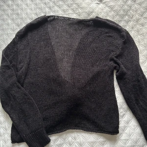 Svart stickad tröja med knyt - Säljer en svart stickad tröja med en snygg knytning baktill. Tröjan har långa ärmar och låg i ryggen. Perfekt för en stilren look. Finns även en beige jag säljer i mina annonser 🦋🤍🤎