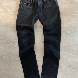 Svarta jeans från Hysteric Glamour - Snygga svarta jeans från Hysteric Glamour med en cool detalj av nitar vid fickan. Storlek S, midjemått: 39cm, längd: 101cm