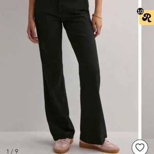 Svarta kostymbyxor från Nelly - Snygga svarta kostymbyxor från Nelly med låg midja, säljer då de är för korta för mig men de är i fint skick. Jag ska självklart ta bort katthåret innan de säljs!🤗