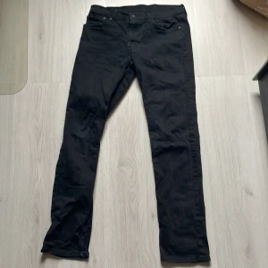 Svarta Levi's 511 jeans - Säljer ett par svarta Levi's 511 jeans. De har en slim passform och är tillverkade i ett slitstarkt denimtyg. Klassisk design med fem fickor och knappgylf. Perfekta för en stilren look.