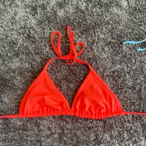 Neon orange bikiniöverdel - Snygg  bikiniöverdel med knytband i nacken och ryggen.