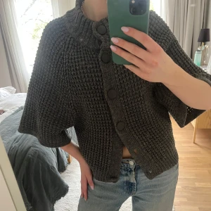 Trekvartsärmad kofta  - Grå stickad kofta med korta ärmar. Dock saknas en knapp men brukar bära tröjan me bara 4 knappar eller öpppen!!💕 