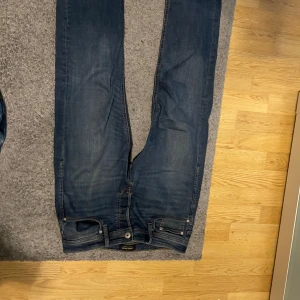 Blå jeans från Jack & Jones - Säljer ett par klassiska blå jeans från Jack & Jones. De har en snygg och tidlös design med normal passform och midwaist. Perfekta för en avslappnad stil.