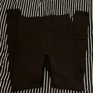 Svarta träningsbyxor med hög midja - Säljer ett par svarta tights med hög midja. De är stretchiga och sitter tight mot kroppen. Sitter bekvämt och är perfekta för träning eller en lugn dag. Har blivit väl omhändertagna, bara att trycket har försvunnit i tvätten.