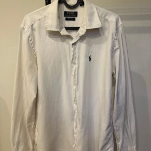 Vit skjorta från Polo Ralph Lauren - vit skjorta från Polo Ralph Lauren i slim fit-modell. knappar framtill och loggan på bröstet. Perfekt för en stilren och tidlös look.