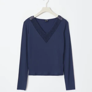 Mörkblå långärmad topp med spetsdetaljer - Elegant mörkblå topp med v-ringning och spetsdetaljer vid halsen. Perfekt för en stilren look.