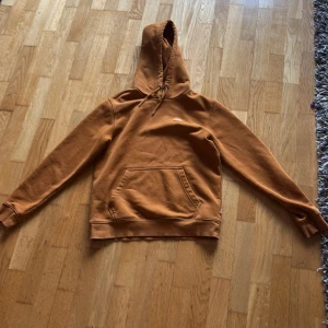Brun hoodie från Dickies - Säljer en snygg brun hoodie från Dickies. Den har en klassisk design med en stor ficka framtill och justerbar huva. Perfekt för en avslappnad stil. Passar bra till både jeans och joggers. Köpare betalar för frakt. Pris kan diskuteras