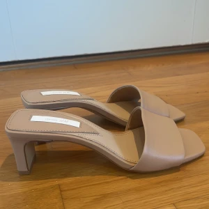 Beige klackskor från H&M - Snygga beige klackskor från H&M med öppen tå och fyrkantig klack. Perfekta för en stilren look. Tillverkade i syntetmaterial med en elegant design. Jag säljer de för att de är lite för små på mig, knappt använda💋säljer för 150-200kr❤️