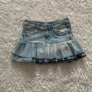 Jeanskjol med volangdetaljer - Lågmidjad jeanskjol omsydd från ett par jeans. Midjemått tvärsöver- 33cm stretchig  Längd- 32cm 