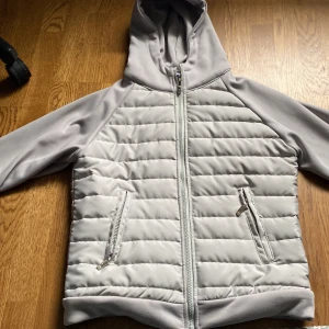 Ljusgrå cardigan strl s men passar även xs. Pris kan diskuteras - Snygg ljusgrå pufferjacka med huva och dragkedja framtill. Jackan har quiltade partier på bröst och rygg samt två fickor med dragkedja. Perfekt för kyliga dagar och enkel att matcha med olika outfits.