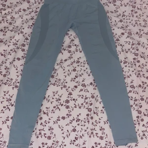 Ljusblå tights från NVGTN  - Säljer ett par ljusblå träningstights från NVGTN. De har hög midja och är tillverkade i ett stretchigt material som sitter tight men ändå bekvämt.
