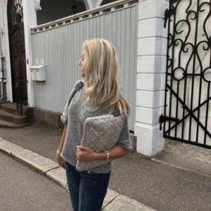 Grå stickad tröja - Säljer en mysig grå stickad tröja med korta ärmar. Perfekt för lager-på-lager eller som den är. Tröjan har en rund hals och ribbade kanter.