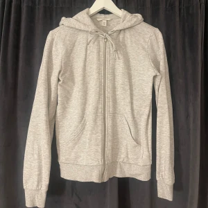 grå kofta från hm - super fin grå hoodie med dragkedja från hm i storlek xs, den har en luva med snören som man kan spänna in eller göras till en rosett som på bilden❣️❣️