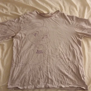 Ljuslila Tune Squad t-shirt H&M - Pris går att diskutera och ändra. Den är bara använd ett fåtal gånger men är ostrycken,T-shirt i ljuslila från H&M med Tune Squad-tryck och stor Lola Bunny-illustration på framsidan. Baksidan har stor text i lila och vitt. Klassisk passform med rund hals och korta ärmar. Perfekt för dig som älskar Space Jam och Looney Tunes. 