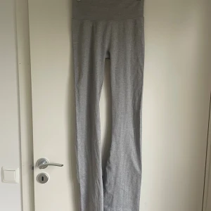 Grå ribbade yoga pants från H&M Move - Superbekväma träningsbyxor från H&M Move i strl S. Byxorna är högmidjade med utsvängda ben och har en tight passform upptill. Använda 2-3 ggr. 
