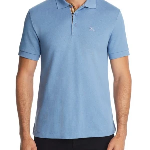 Ljusblå Burberry Piké - Schysst ljusblå piké från Burberry, storlek L och inte använd särskild mycket. Säljer pga samlar till resa nästa år, nypris runt 2800kr mitt pris 1050kr men kan sänka! Hör av er vid frågor eller funderingar.