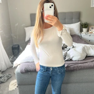 Vit långärmad tröja från 157 - En enkel och stilren vit långärmad tröja från 157. Tröjan har rund halsringning och är gjord i stretchigt material 💗