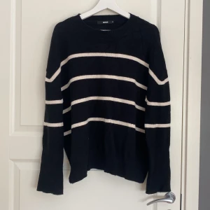 Svartvit randig stickad tröja Bik Bok - Mysig svart stickad tröja från Bik Bok med vita horisontella ränder. Tröjan har en relaxed, lite oversized passform och långa ärmar. Perfekt för kyliga dagar nu inför hösten och enkel att styla med jeans eller mjukisbyxor.🖤