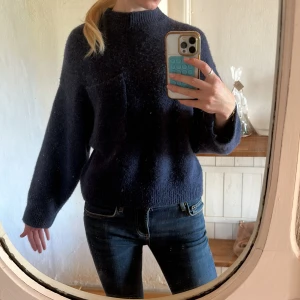 Mörkblå stickad tröja - Mysig mörkblå stickad tröja med rund hals och en stor bröstficka. Så snygg och endast använd fåtal gånger! Gjord i ull och alpacka. Bröstficka på ena sidan vilket är så snyggt💕 Från otherstories