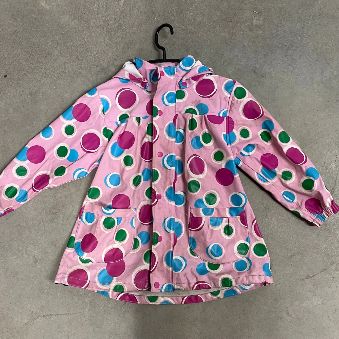 Rosa regnjacka med färgglada prickar