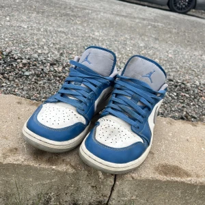 Nike Air Jordan 1 Low blå/vit - Nike Air Jordan 1 Low sneakers i blått och vitt med grå detaljer. Skorna är i okej skick 