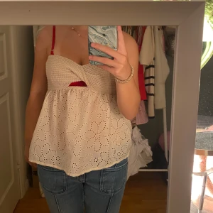 Beige virkad och broderad linnetopp - Supersöt beige linnetopp med virkad överdel och broderade blommor på den vida nederdelen. 