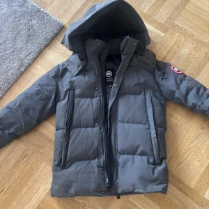 Canada Goose Wyndham - Riktigt fin canada goose jacka i modellen Wyndham, jag har haft den i många år och den är i väldigt fint skick förutom att sömmen på högra sidan av jackan har gått upp lite längst ner. Det är en enkel fix för den som kan sy. Hör gärna av er med eventuella frågor eller funderingar.