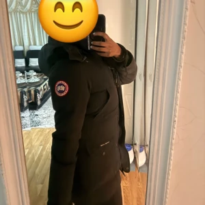 Svart dunjacka från Canada Goose - Säljer en svart dunjacka från Canada Goose med klassisk patch på ärmen. Jackan har hög krage, långa ärmar och dragkedja framtill. Perfekt för kalla dagar och har en stilren, tidlös design som funkar till det mesta. Strlk: xs men passar mig som har s/m. Väldigt använd dock men är köpt för 12000 (2020). Finns päls med ifall man vill! Priset kan disukteras pga skador vid handskarna längst ut på armen. Skriv för fler bilder!!!!😇