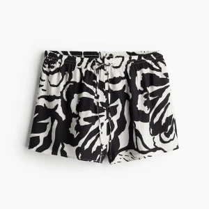 Svarta och vita  shorts - Snygga shorts med svart och vitt blommigt mönster och bekväm snörning i midjan. De har en loose passform och är perfekta för varma dagar. Materialet känns lätt och luftigt, vilket gör dem sköna att bära hela sommaren.
