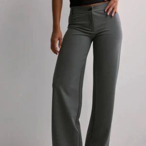 Gråa kostymbyxor - Keep it up low waist suit pants från Nelly i storlek s med låg midja. Har aldrig använt de så de är i nyskick och superfina💕De är slutsålda på deras hemsida. (Bilderna är från nellys hemsida). 
