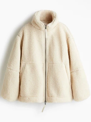 Beige teddyjacka med dragkedja - Mysig beige teddyjacka med hög krage och dragkedja framtill. Jackan har två stora fickor och en loose passform som ger en avslappnad vibe. Perfekt för kyliga dagar när du vill vara både varm och stilren.