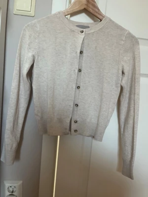 Beige kofta från H&M med knappar - Säljer en beige kofta från H&M i storlek XS. Har använt max 2 gånger 💘