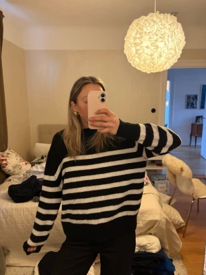Svartvit randig stickad tröja H&M - Säljer en svart och vit randig stickad tröja från H&M i storlek M. Tröjan har lång ärm, rund halsringning och en loose fit. Perfekt för alla tillfällen. 