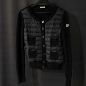 Moncler cardigan  - Säljer denna super fina Moncler dam cardigan i svart. Den är i storlek M men passar S mycket bättre, den är i super fint skick utan fläckar eller hål. Nypris på en liknande jacka är 11 000kr men säljs nu för endast 3799kr. Vid frågor eller efterfrågan på fler bilder skicka ett meddelande🥰💕