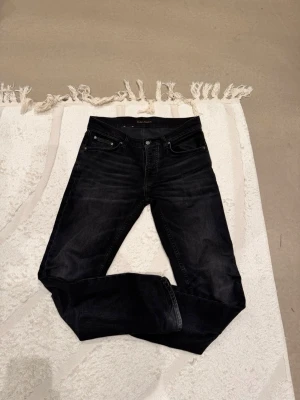 Svarta jeans från Nudie Jeans Co - Säljer dessa as feta jeans från nudie. Jeansen är svarta med gråa slitningar som gör jeansen unika och väldigt snygga. Modell Solid ollie. Pris kan diskuteras vi snabb affär!