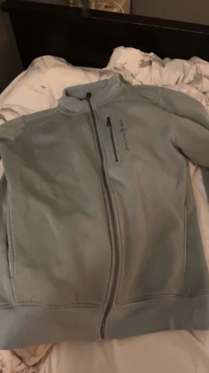 Grå vindjacka från sail racing  - Fin o varm sail racing finns i Borås!!! Ops liten fläck vid dragkedjan men går säkert bort i tvätten 