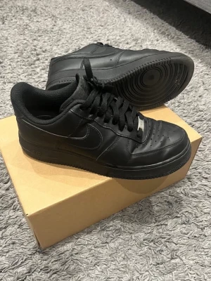 Svarta air force 1 - Jag köpte dessa skor för 3 år sedan, men jag har inte använt dem på 3 år också typ. Så jag tänkte att det är bättre att sälja, dem är creasade som ni ser på bilderna. Men annars är de Inget fel på dem. De är bekväma, 8/10 skick. De är storlek 42,5. Jag har inte kvar orginalboxen och kvitto, men de är 100% äkta. Och jag kommer frakta dem i en annan box så de inte blir skadade. Hör av er vid frågor! 