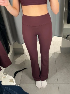 Vinröda bootcut träningsbyxor H&M Move  - Säljer ett par vinröda bootcut träningsbyxor från H&M Move i storlek XS. Byxorna har hög midja och är gjorda i mjukt, stretchigt syntetmaterial som sitter skönt mot kroppen. Perfekta för gymmet eller yoga och har en stilren look utan mönster.helt slutsålda på hemsidan och använda 2 gånger så väldigt bra skick💕