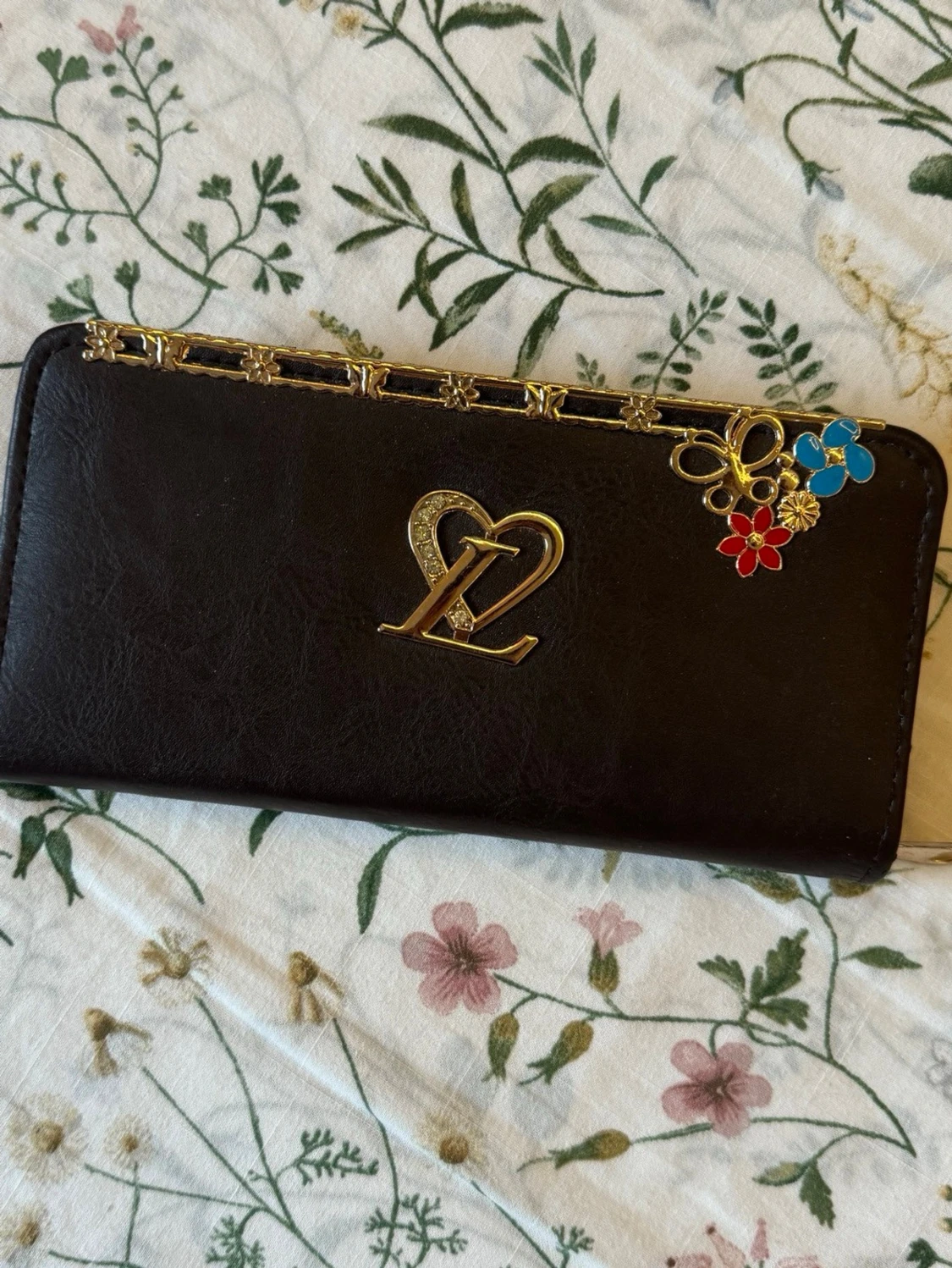 Plånbok med gulddetaljer och blommor