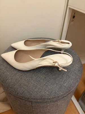Vita pumps med spetsig tå och låg klack - Ett par vita låga klackar med spetsig tå, de är köpa second hand men aldrig använda av mig och är i fint skick. Storlek 38