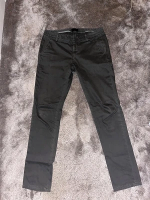 Gråa Dondup chinos - Säljer dessa Dondup chinos perfekt för festliga sammanhang eller bara till vardags.                               Storlek-32