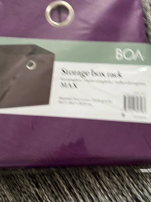Förvaring  - Bilderna visar en lila förvaringsbox från BOA Design, inte en väst. Produkten är tillverkad i non-woven material och har en metallring för enkel hantering. Måtten är 27x27x28 cm.